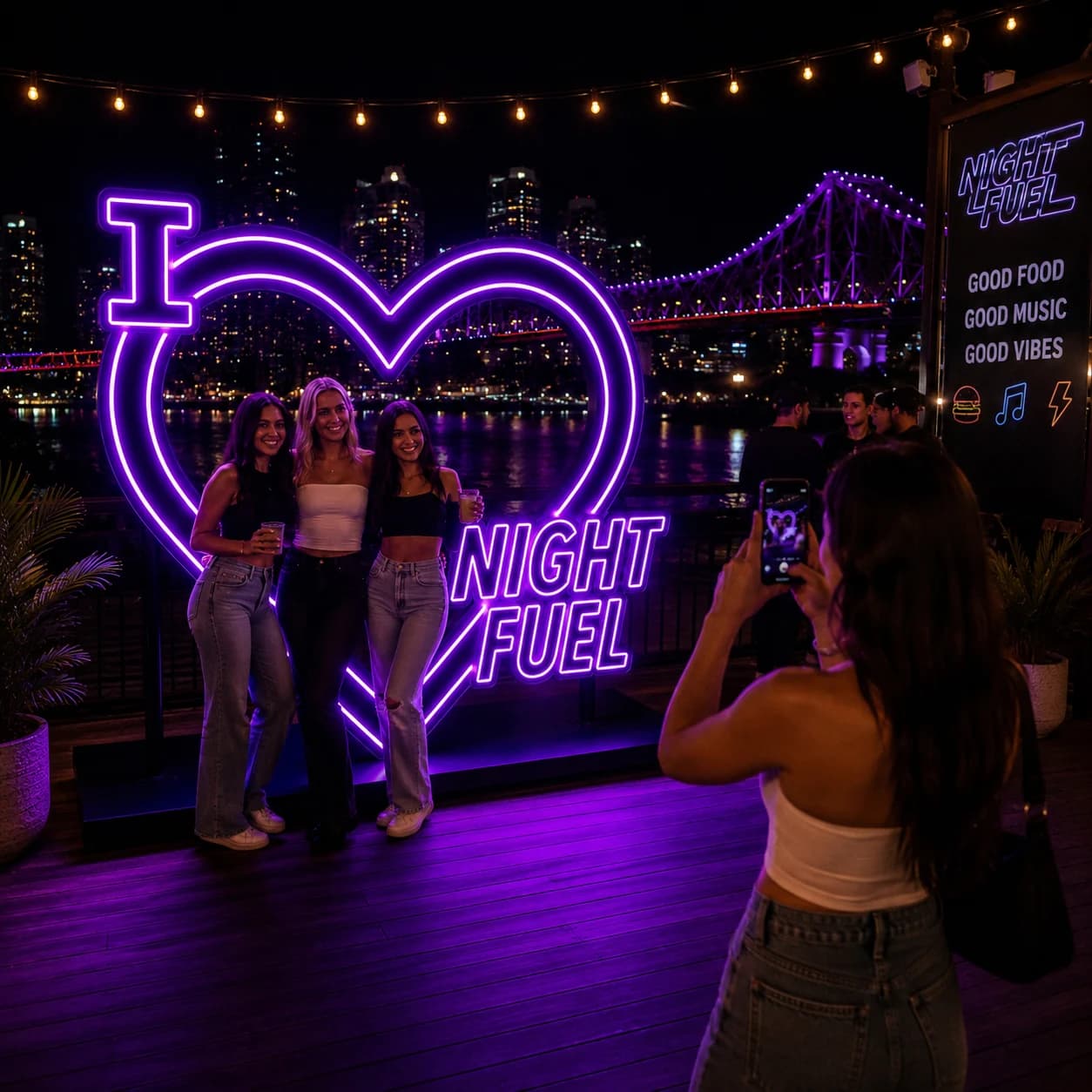 Friends posing at a Night Fuel illuminated photo installation concept